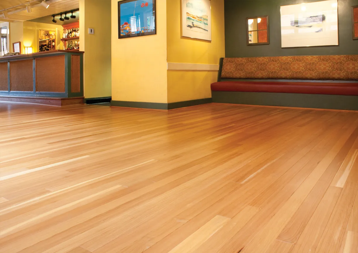 Restored strip hardwood floor running through a bright open interior