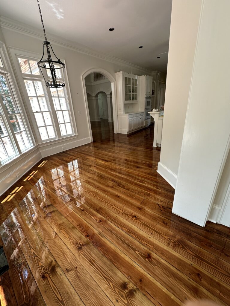 Refinished glossy pine hardwood floor in a dining room